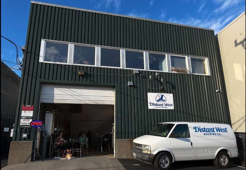 A warehouse building with a white van parked in front.