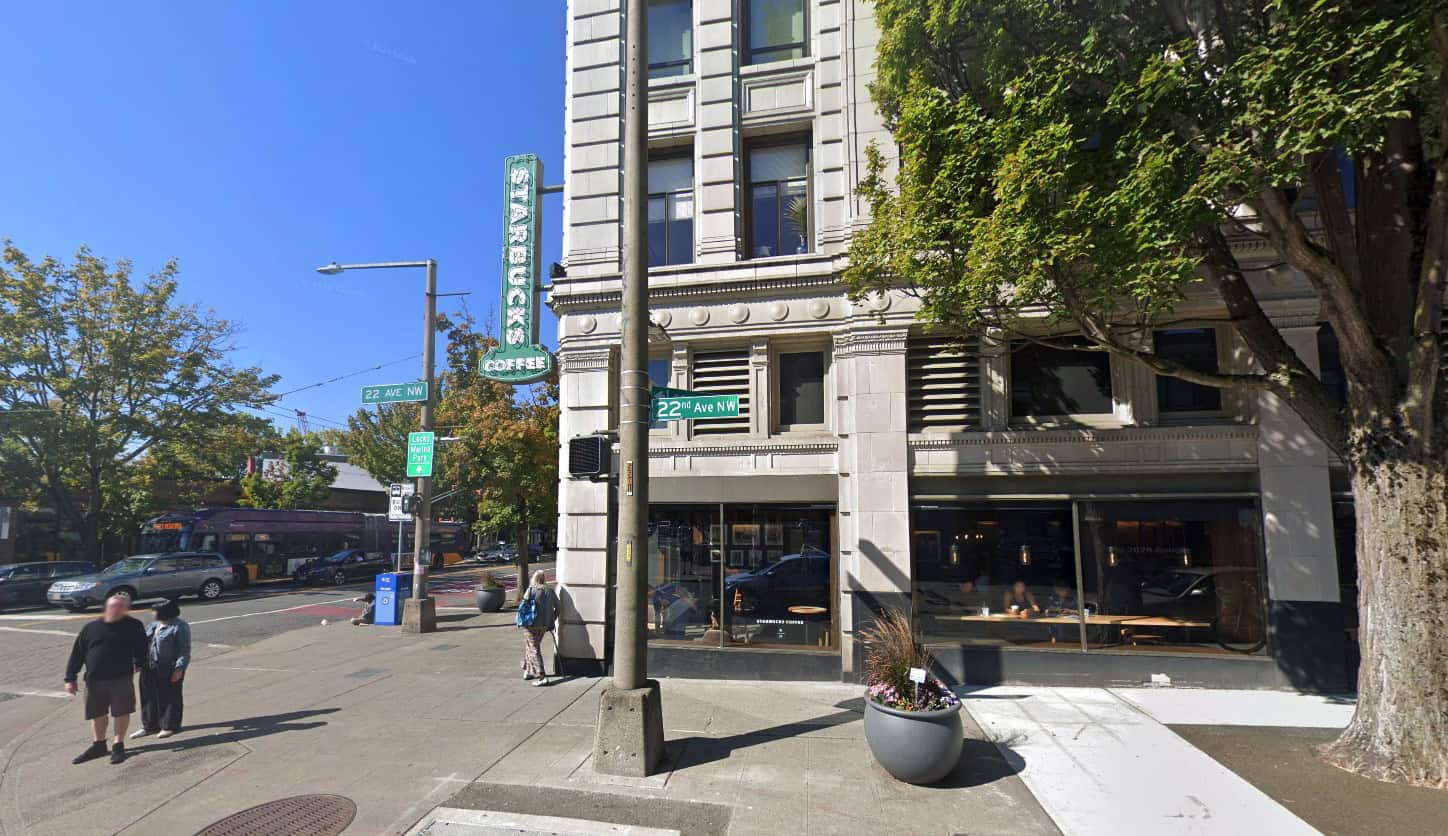 A corner building with people standing on the sidewalk.